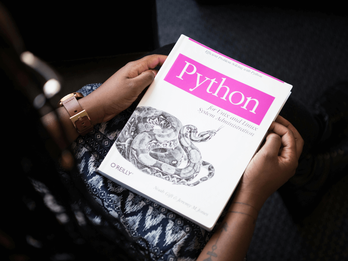 Tech professional reading a book about computer programming in engineering.